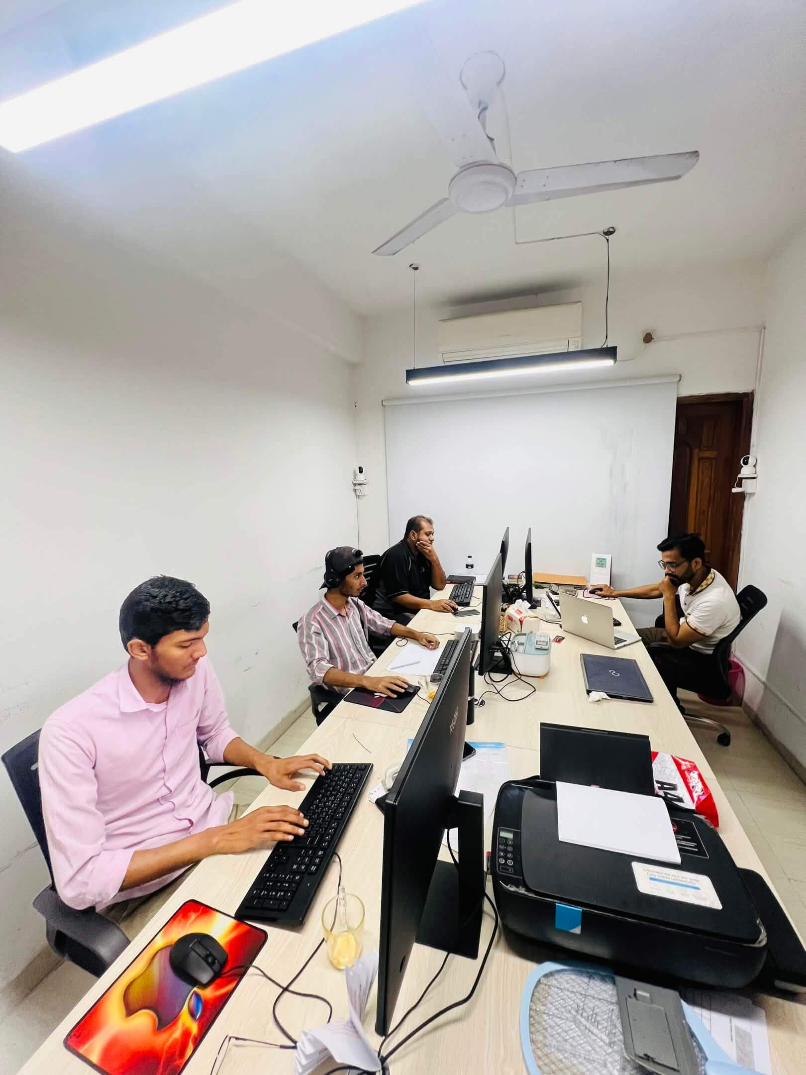creative team working at desks in a modern office environment collaborating on ecommerce projects